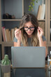 © simona - Professional young woman working in modern office with laptop and desktop computer – focused business environment, digital work, smart working and technology concept