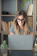 © simona - Professional young woman working in modern office with laptop and desktop computer – focused business environment, digital work, smart working and technology concept
