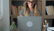 © simona - Professional young woman working in modern office with laptop and desktop computer – focused business environment, digital work, smart working and technology concept