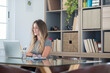 © simona - Professional young woman working in modern office with laptop and desktop computer – focused business environment, digital work, smart working and technology concept