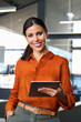 © Stock 4 You - Vertical portrait of smiling hispanic young woman using pad tab computer for business. Executive CEO businesswoman saleswoman holding digital tablet pc device for work in office, looking at camera