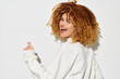 © SHOTPRIME STUDIO - Happy woman with curly hair smiling on a bright white background, wearing a cozy oversized sweater Joyful expression, youthful vibe, perfect for lifestyle and fashion themes