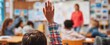 © Studio Nova - The student raising hand eagerly to participate in a classroom discussion.