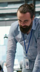 Fototapete - Vertical video Startup engineer and colleague with paraplegia brainstorming, working with machine learning tech. Man in wheelchair and coworker in office transforming data into AI predictive models