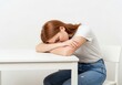 © Designer - Exhausted woman rests her head on her arms on a white desk