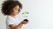 © Amiril - a child with Hands holding a young plant isolated on a white background