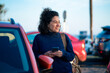 © Westend61 - Smiling businesswoman with smart phone standing by car