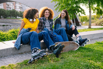 Three young skater friends laughing and enjoying carefree moments together in a vibrant park, soaking up the sunny day and good vibes