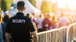 © A2Z AI  - A security guard stands watch at a crowded outdoor event, ensuring safety and order amongst the attendees with a watchful eye over the surroundings.