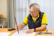© leungchopan - Old asian man practicing calligraphy at home