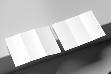 Poster - Two blank white tri-fold brochure mockups, partially open and angled on a gray surface with contrasting shadows. Offers a modern, dynamic feel for design presentations.