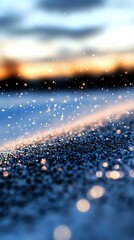 Poster - Magical winter scene with sparkling snow crystals glowing at sunset, creating dreamy bokeh effect against blurred blue and orange sky background.