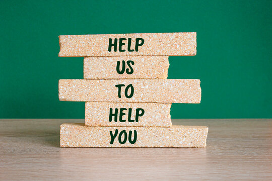 HELP US TO HELP YOU word on brick blocks. Beautiful green background, wooden table. Motivational concept. Copy space