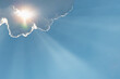 © Tetra Images - Sunlight shining through clouds against blue sky