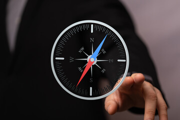 Poster - Conceptual image of a businessman using a digital compass for navigation and direction.