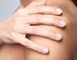 © fara - Close-up of a woman's hand gently touching her shoulder, emphasizing healthy, smooth skin and self-care. Ideal for beauty, wellness, and dermatology concepts.