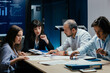 © Suteren Studio - Business executives and assistants brainstorming investment risk evaluation in corporate boardroom