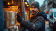 © Rasy - Delivery worker sorting packages into van on busy street during winter