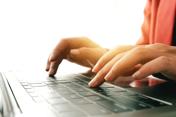 Wall Mural - close-up portrait typing keyboard on laptop computer. working online on white table at office. faceb
