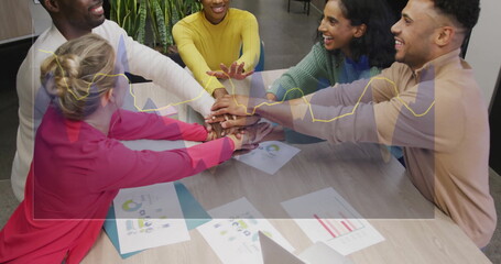 Poster - Colleagues wearing tops stacking hands in office meeting room, with laptop charts and graphs
