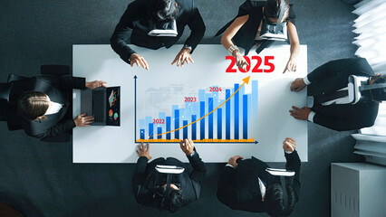 Poster - Collaborative business meeting showcasing advanced technology where professionals analyze growth projections for 2025 using innovative charts and engaging discussion. Amity