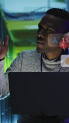 Poster - Animation of social media icons over african american male engineer using laptop at server room