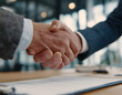 © Jack - Accord professionnel entre deux collègues dans un bureau moderne – poignée de main et contrat signé