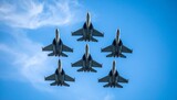 Photo footage of a fighter jet in formation, showing multiple jets flying in tight formation with their wings aligned against a blue sky