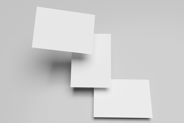 Poster - Three white A4 paper, magazine, or business card mockups floating diagonally with soft shadows isolated on grey background.