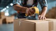 © BlackLion - Worker seals cardboard box with tape in a shipping warehouse during the day