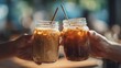 © Marry93 - Two hands clinking glass jars of iced coffee, open right frame