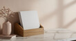 © Elena Astahova - *Modern flyer mockup stacked in wooden holder on marble countertop, soft natural lighting for warm inviting aesthetic with copy space*