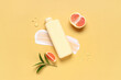 © Pixel-Shot - Composition with bottle of shower gel, grapefruit and cream smears on yellow background