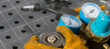 © kurgu128 - hand opens gas cylinder for welding, close-up, against metal table