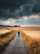 © Romain - Female cyclist riding along a golden countryside road at sunrise.