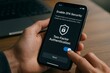 © Татьяна Евдокимова - Close up of hands activating 2FA on mobile phone, enhancing account security in office setting
