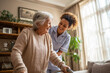© MobiWall - Caregiver helps senior woman walk with walker. Empathy, support, home care. Healthcare promo, editorial, web use.
