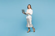 © ViDi Studio - Full body young employee IT business woman corporate lawyer wear shirt classic formal clothes work in office hold use laptop pc computer isolated on plain pastel light blue background studio portrait.
