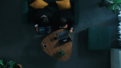 Poster - Top down aerial view of businessman sitting while working on laptop while skilled colleague walking in to room and analyze financial data together. Business team sharing marketing idea. Directorate.