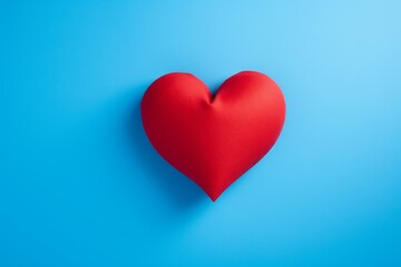 Poster - Red heart shape on blue background representing love, care, and affection, ideal for valentine's day or romantic themes