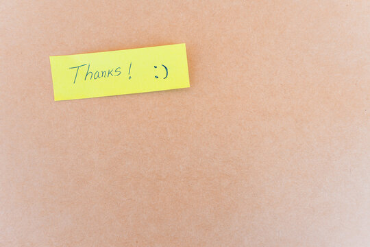 Thank you note that says thank you, handwritten with blue pen on a solid background	
