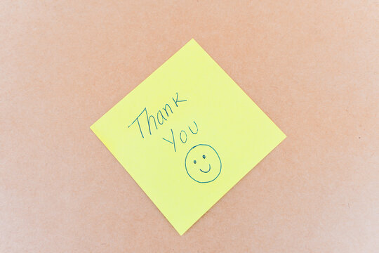 Thank you note that says thank you, handwritten with blue pen on a solid background	
