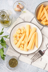 Wall Mural - Plate with tasty canned corn cobs on light background