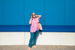 © KikoStock - Stylish senior woman talking on phone in front of blue wall