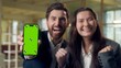 © Yuliia - Excited two business woman man celebrating win showing mobile phone green screen chroma key mock up Caucasian Korean businesspeople cheering winner victory money smartphone excitement triumph office
