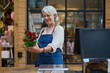 © alvaro - Senior florist holding red flowers in flower shop