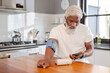 © Wavebreak Media - African American man checking blood pressure using monitor and phone in kitchen, copy space