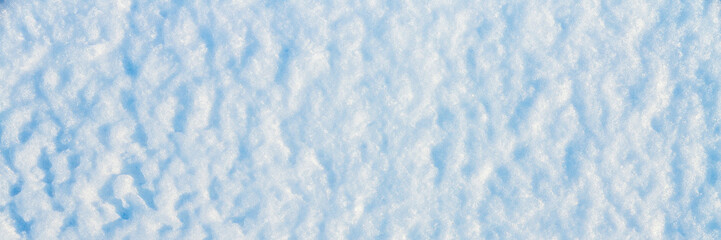 Wall Mural - Natural snow texture. The surface of the snow crust. Snowy ground. Winter background with snow patterns. Perfect for Christmas and New Year design. Closeup top view.