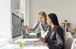 © Studio Romantic - Two successful women analyzing financial details and looking through digital file on PC, posing at office desk, working together as team. Female accountants checking electronic spreadsheet