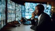 © Bambalino Studio - A man in a suit is talking on a cell phone while sitting at a desk with multiple computer monitors